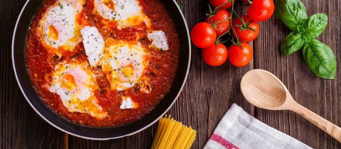 black-frying-pan-with-spaghetti-sauce-near-brown-wooden-691114